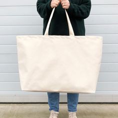 The bag you'll reach for everytime you head out the door! Our extra large canvas bags are SO useful. Perfect for the gym, the beach, weekends away and your weekly shop. Actually they are pretty handy for everything!These oversized tote bags have been made from sturdy natural canvas. Lovingly made in the UK. Hooray! Made in the UK 15oz heavy weight natural canvas Deep flat base Mid-length handles 730mm by 440mm by 170mm (28¾ by 17½ by 6¾ inches) Hen Party Badges, Giant Canvas, Extra Large Tote Bags, Canvas Grocery Bag, Oversized Tote Bag, Oversized Tote, Big Bag, Slogan Tee, Weekend Bag