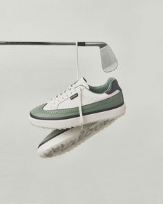 a white and green tennis shoe hanging from a rack