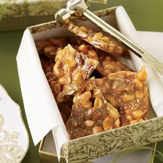 a box filled with nuts on top of a table next to plates and utensils