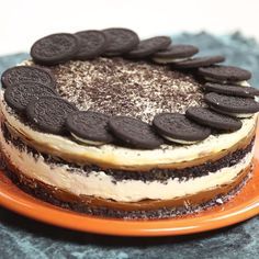 a cake with oreo cookies and cream frosting sitting on top of an orange plate