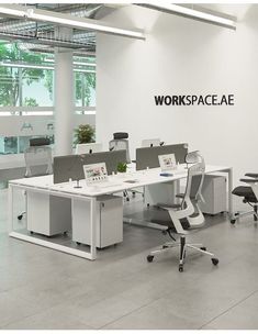 an office space with desks and chairs in front of a wall that says workspace ae