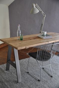 a desk with a chair, lamp and bottle on it