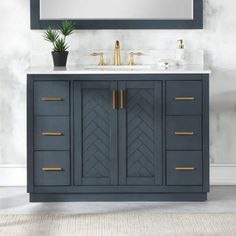 a bathroom vanity with two sinks and a large mirror on the wall above it, along with a potted plant