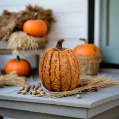 an orange pumpkin sitting on top of a wooden table next to corn and other fall decorations