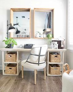 a home office with two framed pictures on the wall and wicker baskets under the desk