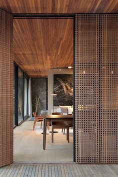 the interior of a modern home with wood and stone walls, floor to ceiling windows, and wooden furniture