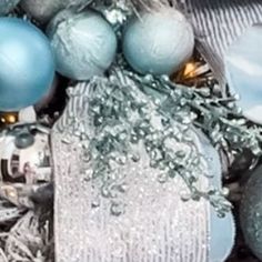 silver and blue ornaments are piled on top of each other in tinsel, glass ornament balls