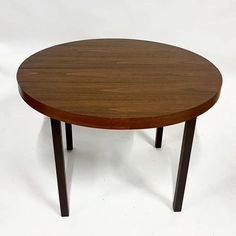 a round wooden table sitting on top of a white floor