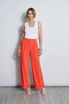 Meet the pant of the season! Our Fluid wide leg Crepe Pant features pleats at the waist and a cuffed hem. Worn with its matching vest or with one of Elie's must have shirts or knits, it is the perfect pant addition to your wardrobe. High Rise Wide Leg Fluid Crepe Pleated Pant Runs true to Size Model is 5'9" and wearing size 2 Dry Clean Only Imported Style #: ETR41359 Classic Wide Leg Pants For Spring Daywear, Classic Sleeveless Bottoms For Spring, Pleated Pant, Woven Handbags, Perfect Pant, Leather Weaving, Pleated Pants, New Outfits, Rib Knit