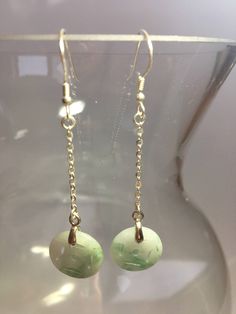 This pair of long dangle & drop earrings are made of quality Chinese coin shaped green & white jade drops and 925 Sterling silver hooks and wire. The fine green & white jade are icy and natural. The jade is carved into a Chinese antique & vintage coin shape. All metals parts are sterling silver. The simple designs with long dangle donut & round shaped jade drops demonstrate elegance and contemporariness. Some highlights of this pair of graceful Chinese jade earrings are: *Hig Single Green Long Drop Earring, Green Single Long Drop Earring, Jade Dangle Earrings For Pierced Ears, Green Long Drop Earrings, Jade Earrings With Dangling Beads As A Gift, Pierced Jade Dangle Earrings, Green Long Drop Earrings For Gift, Green Long Drop Earrings As Gift, Green Round Pendant Earrings For Gift