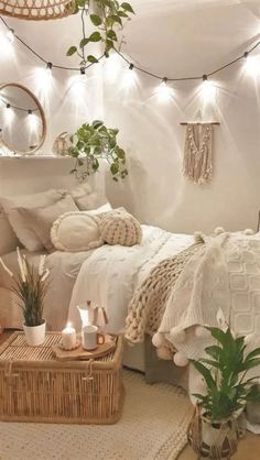 a bedroom with white walls and lights above the bed, plants in baskets on the floor