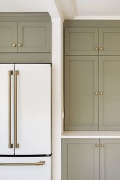 an instagram photo of a kitchen with green cabinets and white refrigerator freezer doors