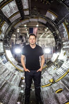 a man standing in the middle of a large machine room with his arms crossed and looking at the camera