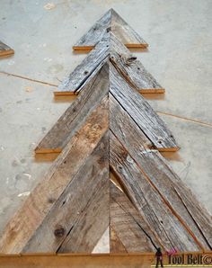 a wooden christmas tree sitting on top of a floor