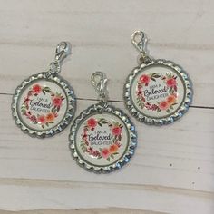 three pendants with flowers and the words i am a beloved mom written on them