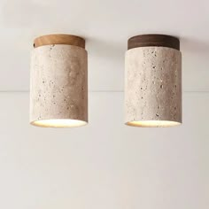 two concrete lamps are hanging from the ceiling