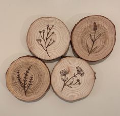 four pieces of wood that have been cut in half with flowers on them, and are sitting on a white surface