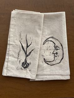 two napkins with designs on them sitting on a table