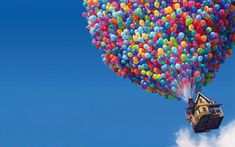 a house is floating in the air with balloons