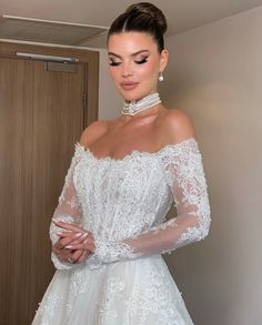 a woman in a white wedding dress standing next to a door