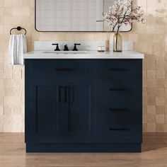 a bathroom vanity with two sinks and a large mirror over the top that hangs above it