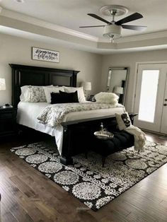 a bedroom with a bed, rugs and ceiling fan in it's center