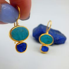 Rough Lapis Lazuli and Turquoise Drop Earrings made out of 18 karat Gold plated Sterling Silver. 100% Handmade Jewellery. LAPIS LAZULI: The sweet sounding, melodic name of this gem is composed of 'Lapis', the Latin word for stone, and 'Azula', which comes from the Arabic and means 'blue'. Historians believe the link between humans and lapis lazuli stretches back more than 6,500 years. The gem was treasured by the ancient civilizations of Mesopotamia, Egypt, China, Greece, and Rome. They valued i Fusion Style Blue Gemstone Earrings, Blue Multi-stone Earrings For Jewelry Making, Ear Art, Latin Word, Lapis Lazuli Jewelry, Lapis Lazuli Earrings, Turquoise Drop Earrings, Peridot Pendant, April 16