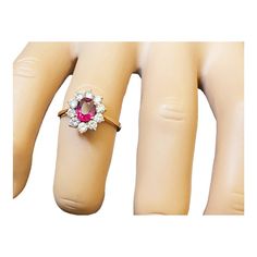 a pink and white diamond ring sitting on top of a mannequin's head