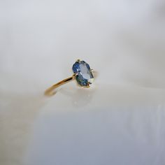 a ring with an oval shaped blue topazte stone on it's side