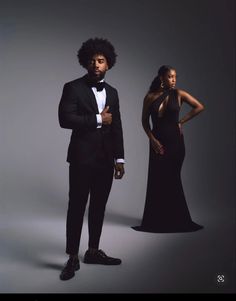 a man in a tuxedo standing next to a woman in a black dress