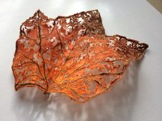 an orange leaf is sitting on a white surface