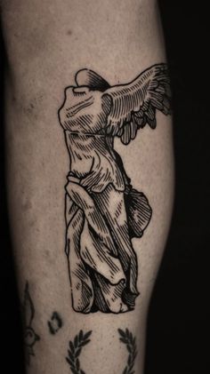 a tattoo on the leg of a man with an angel and wreath around his arm