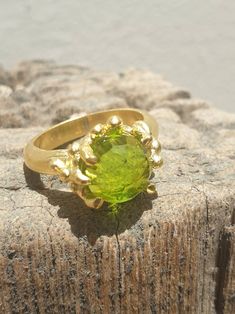 This is gold plated brass peridot ring. A designer handmade ring. It has a design of a coral, holding a green peridot gem. It could be an alternative engagement ring, or a great gift for a loving one. - 14 karat Gold plated brass - Round peridot gem - Free shipping worldwide - Sent in a gift box If you would like to see other rings I have made, please follow this link: https://www.etsy.com/il-en/shop/TamyZurTachshit?ref=seller-platform-mcnav&section_id=17271018 If you would like to go back t Handmade Peridot Wedding Rings, Handmade Peridot Ring For May Birthstone, Handmade Green Brass Rings, Handmade Elegant Peridot Rings, Elegant Handmade Peridot Rings, Unique Green Brass Ring, Unique Green Brass Rings, Unique Green Peridot Rings, Gold Peridot Ring