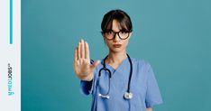 a woman wearing glasses and a stethoscope holding her hand up in the air