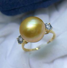 Stunning South Sea Golden Pearl Ring, 11.7mm, Bright Rich Gold Color, Deep Tone with Green overtone, Very High Luster, Absolutely Stunning.   Solid 18k Yellow Gold with Diamonds, Well made and Comfortable to wear. US Size 7.5. Elegant and stunning. Something you can wear forever.  Stunning and Elegant    Lustrous beauty  Pearl ★ Genuine South Sea Golden Pearl ★ Size: 11.7mm ★ Shape: Near Perfect Round ★ Color: Natural Untreated, Bright Rich Sunny Gold, Deep tone with Green overtone, Stunning ★ L Yellow Gold Diamond Rings With High Luster, Yellow Gold Round Diamond Ring With Gemstone, Fine Jewelry Yellow Gold Rings, Gold Diamond Pearl Ring With Prong Setting, Aaa Quality Round Diamond Ring, Gold Pearl Ring With Diamond Prong Setting, Gold Pearl Ring With Gemstone, Gold Pearl Ring With Brilliant Cut Oval, Gold Oval Pearl Ring With Brilliant Cut