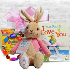 a stuffed rabbit sitting in front of a book and candy box with an easter bunny on it