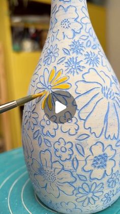 a blue and white vase sitting on top of a table next to a pair of scissors