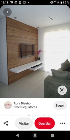 an iphone photo of a living room with a tv on the wall and couches