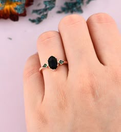 a woman's hand with a black stone ring on it