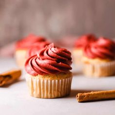 cupcakes with red frosting and cinnamon sticks