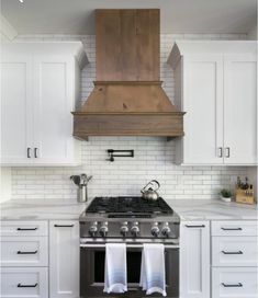 a stove top oven sitting inside of a kitchen next to white cabinets and counter tops