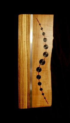 a necklace made out of wood and beads is hanging on the wall in front of a door