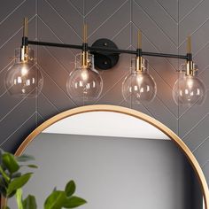 a bathroom light with three bulbs on the wall and a mirror in front of it