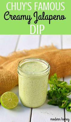 a jar filled with creamy jalapeno dip on top of a wooden table