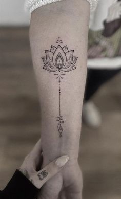 a woman's arm with a lotus tattoo on it