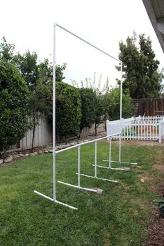 several white poles in the grass near a fence