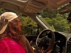 a woman sitting in the driver's seat of a car