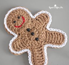 a crocheted teddy bear with red nose and black eyes is shown on a gray surface