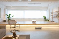 a living room filled with furniture next to a window covered in white curtains and plants