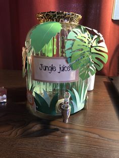 a jungle juicer sitting on top of a wooden table next to a glass bottle